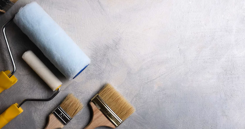 lady sitting with paint brush and blue interiro wall